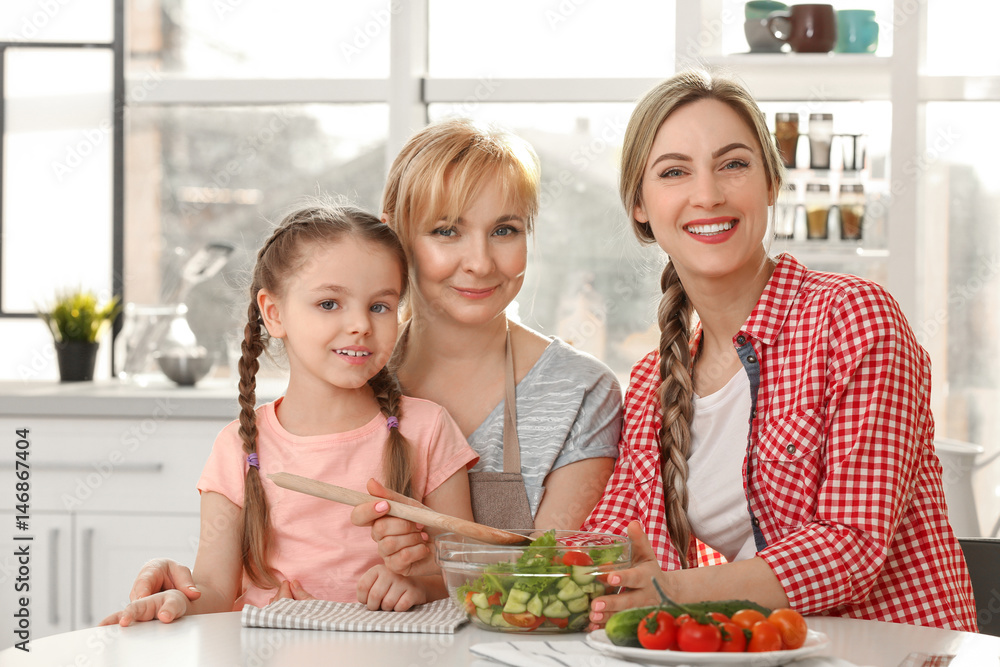 Young woman with mother and daughter in kitchen Young woman with mother and daughter in kitchen