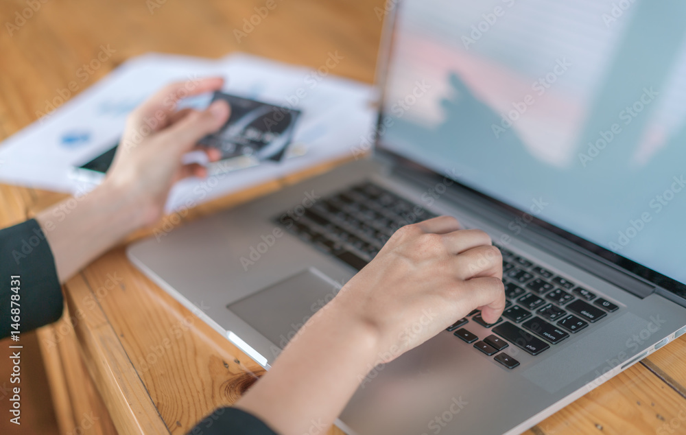 Hands holding a credit card and using laptop computer for online shopping . Hands holding a credit card and using laptop computer for online shopping .