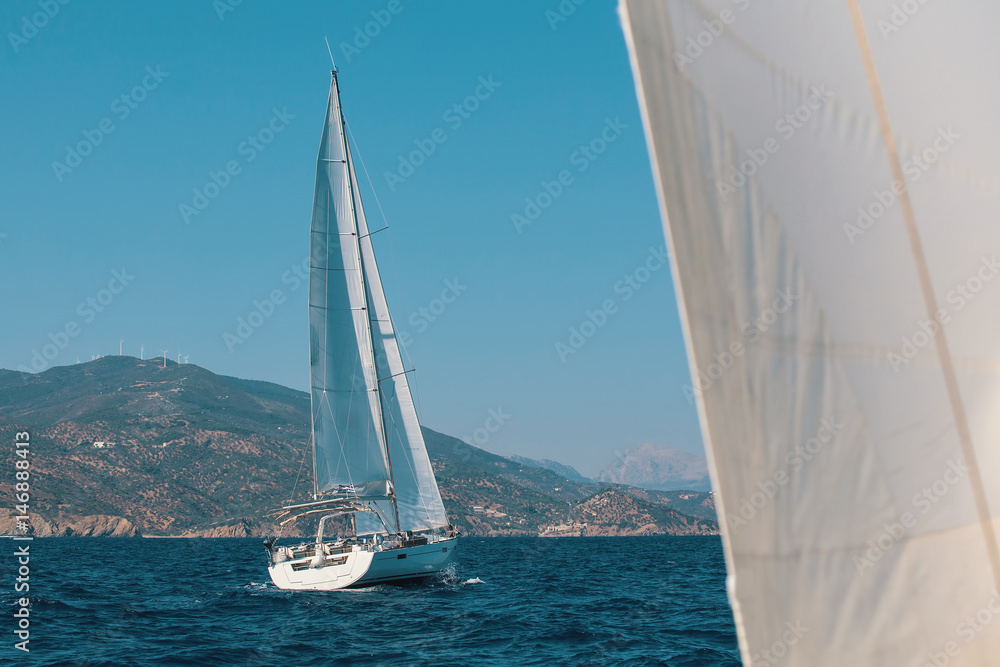Obraz premium Sailboats during a cruise in the Aegean sea. Luxury yachts, marine tourism.