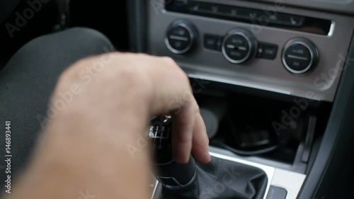 Manual car shift gear changed by hand in automobile interior