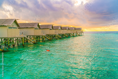 Beautiful water villas in tropical Maldives island at the sunset time . © jannoon028