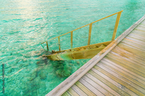 Wood stair into the sea of tropical Maldives island . © jannoon028