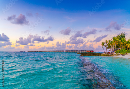 Beautiful sunset with sky over calm sea in tropical Maldives island .