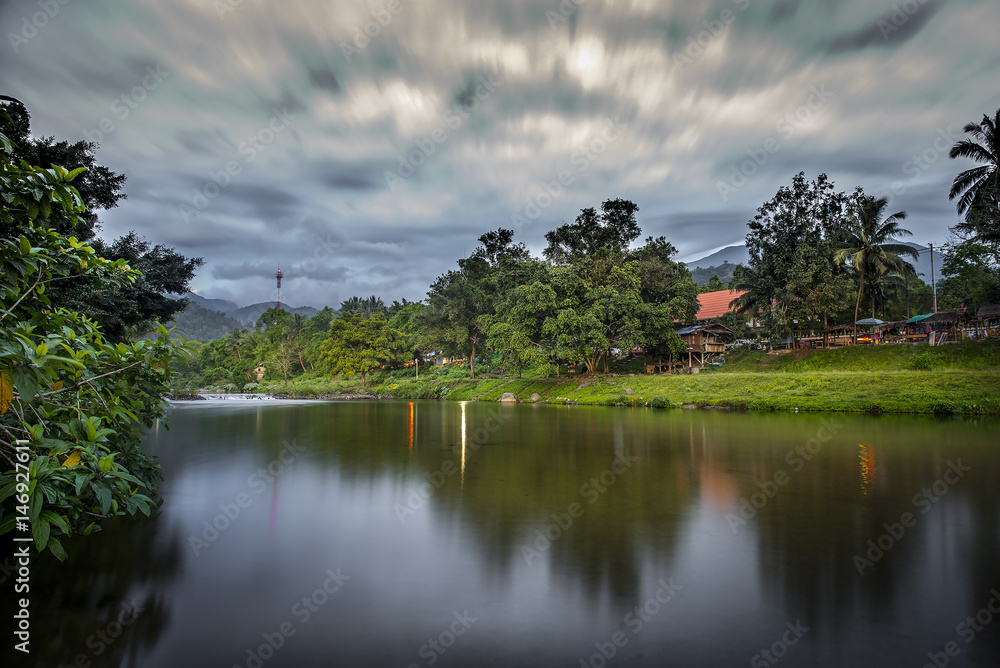 Beautiful view landscape of residence and mountain with blue sky reflected onto the river Beautiful view landscape of residence and mountain with blue sky reflected onto the river