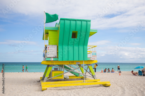 USA, FLORIDA, MIAMI BEACH. APRIL, 2017. Lifeguard tower in a colorful Art Deco style, with blue sky and Atlantic Ocean in the background. World famous travel location. South Beach. © miami2you