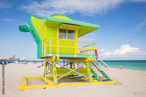 USA, FLORIDA, MIAMI BEACH. APRIL, 2017. Lifeguard tower in a colorful Art Deco style, with blue sky and Atlantic Ocean in the background. World famous travel location. South Beach.