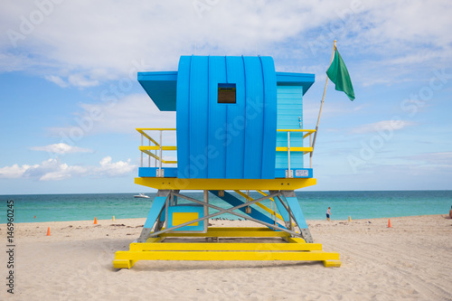 USA, FLORIDA, MIAMI BEACH. APRIL, 2017. Lifeguard tower in a colorful Art Deco style, with blue sky and Atlantic Ocean in the background. World famous travel location. South Beach. © miami2you