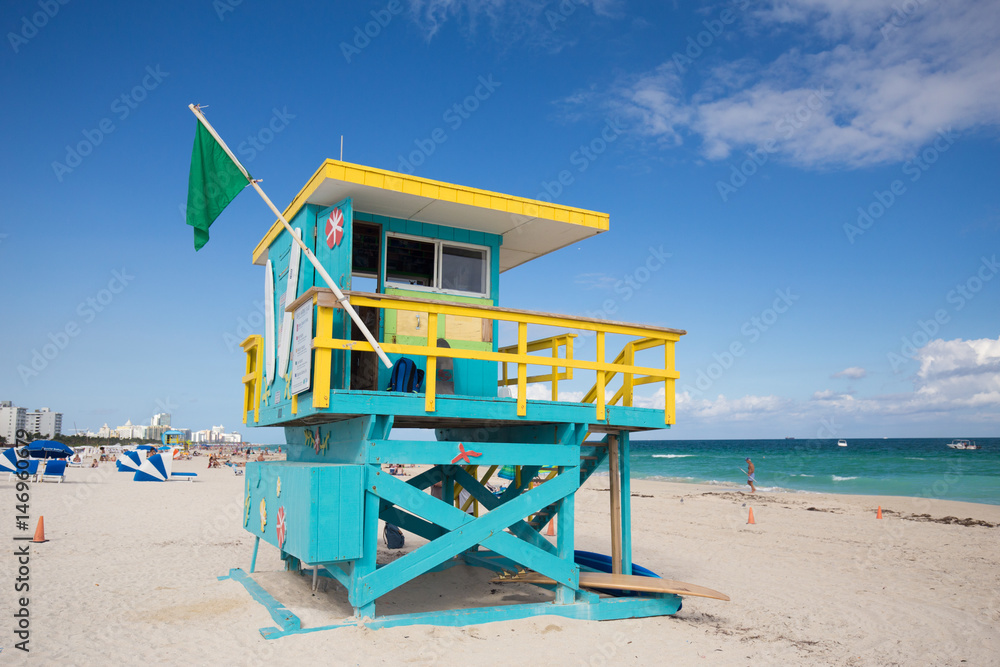 USA, FLORIDA, MIAMI BEACH. APRIL, 2017. Lifeguard tower in a colorful Art Deco style, with blue sky and Atlantic Ocean in the background. World famous travel location. South Beach. USA, FLORIDA, MIAMI BEACH. APRIL, 2017. Lifeguard tower in a colorful Art Deco style, with blue sky and Atlantic Ocean in the background. World famous travel location. South Beach.