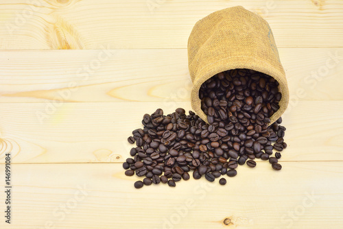 Coffee beans close-up in sack on wood