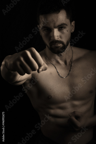 Handsome muscular man giving a punch 