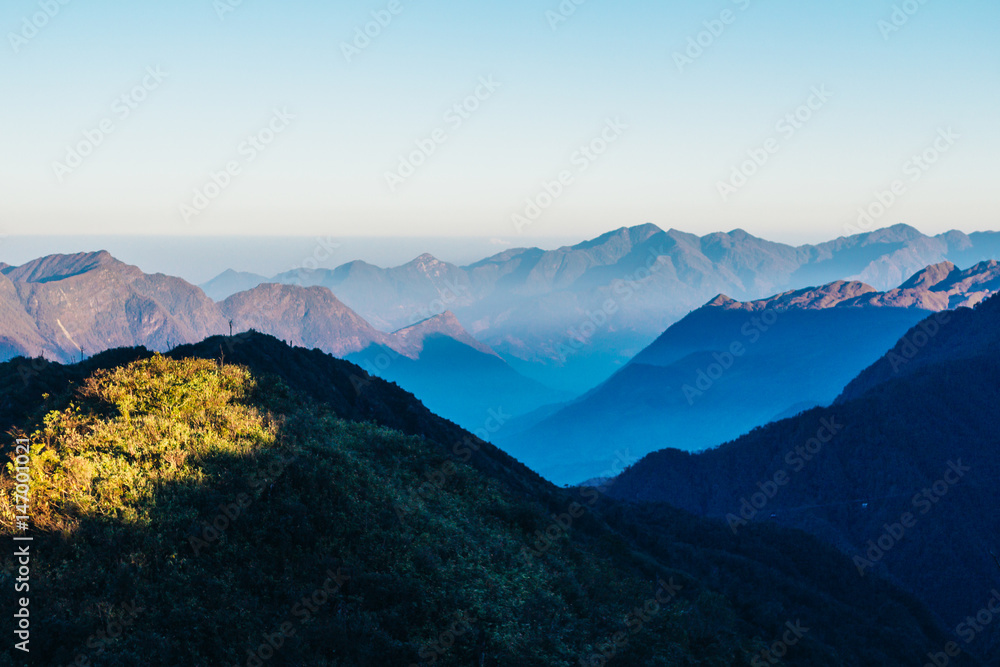 Obraz premium Colourful sunshine on a landscape of beautiful Fan Si Pan (Fansipan) or Phan Xi Pang mountain, the highest mountain in Indochina in Sapa, Hoang Lien National Park, Lao cai province northern Vietnam