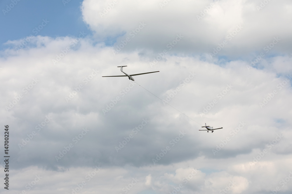 Glider towed on a rope flying on a blue sky background.