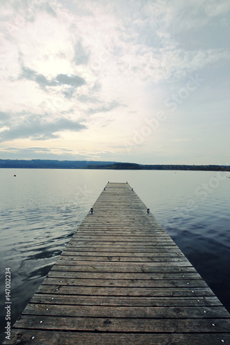 Fototapeta Naklejka Na Ścianę i Meble -  Bridge on the lake. Wooden plank  lake  pier. Long bridge on the lake on  sky background