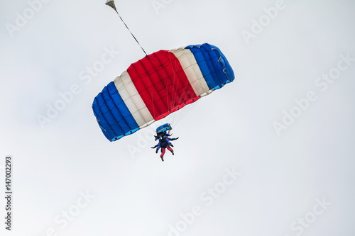 Two Parachutists fly to the sky. Two tandems with parachutists in the air.