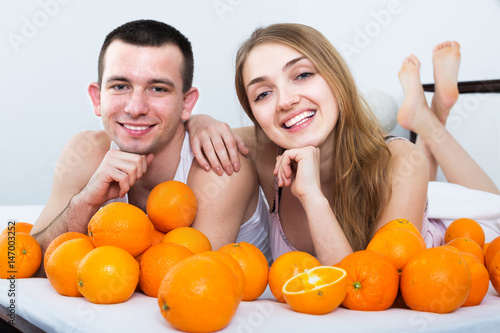 Couple with oranges in bed photo