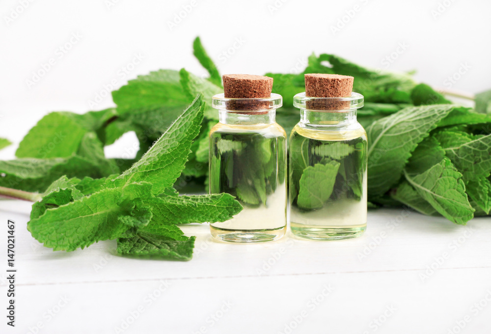 Essential oil of mint with green fresh plant leaves.
Essential oil of mint with green fresh plant leaves.