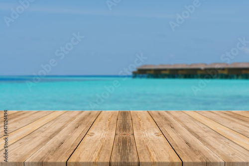 Wooden board empty table top blur sea & sky background. Perspective brown wood table over sea and sky - can be used mock up for montage products display or design key visual layout. summer concepts.