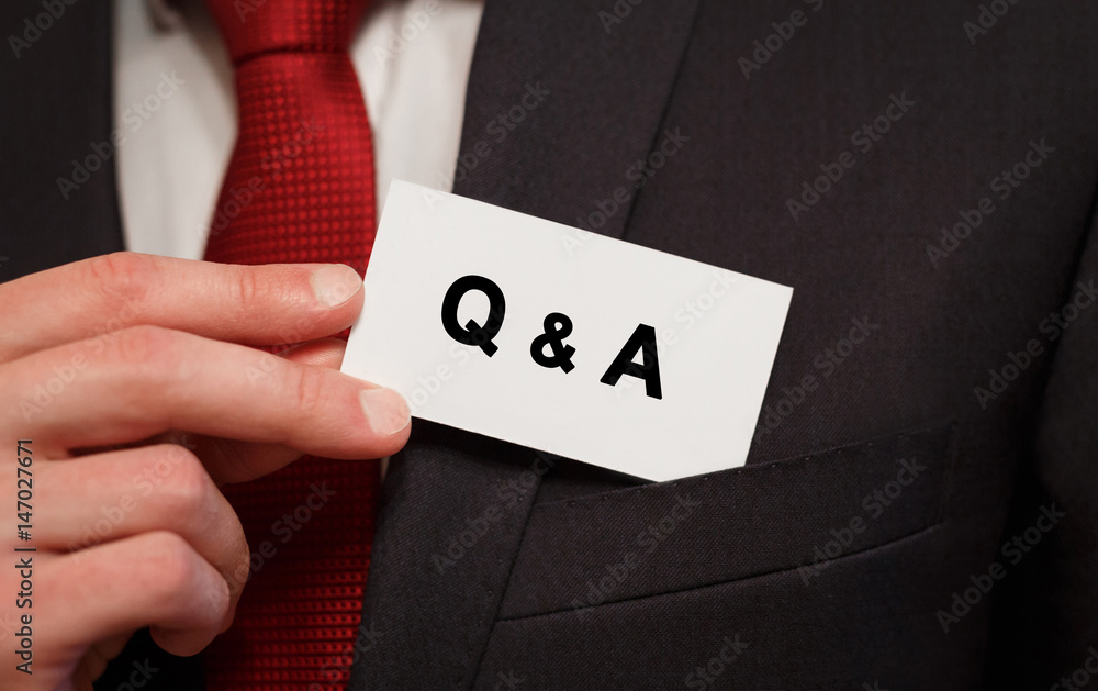 Businessman putting a card with text Q and A in the pocket Businessman putting a card with text Q and A in the pocket