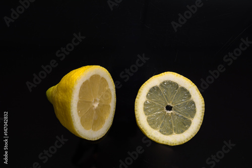 Zitrone mit schnitz isoliert auf schwarzem Hintergrund im Querformat