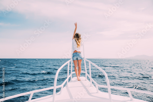 Beauty woman standing on yacht nose on sea background