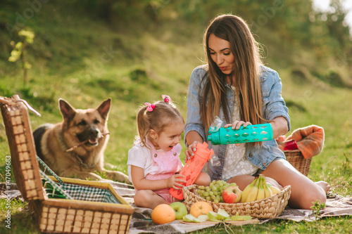 mother and daughter at a picnic with a dog photo