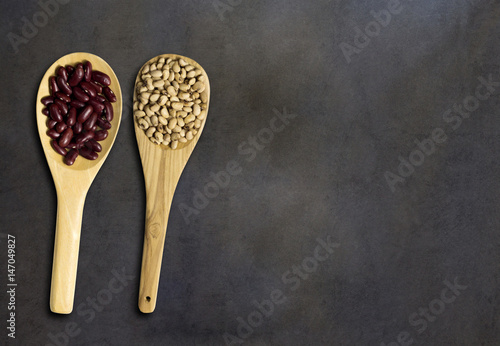 Seed on wooden spoon on dark wood, top veiw