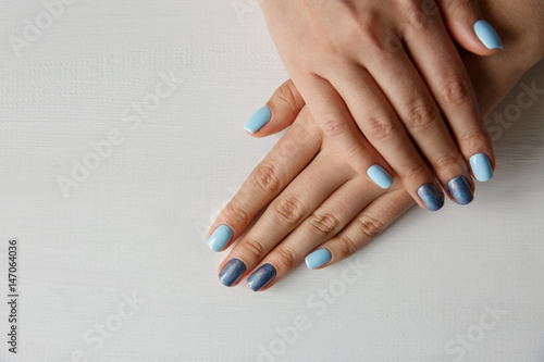 Natural nails with beautiful manicure, blue polish on women nails
