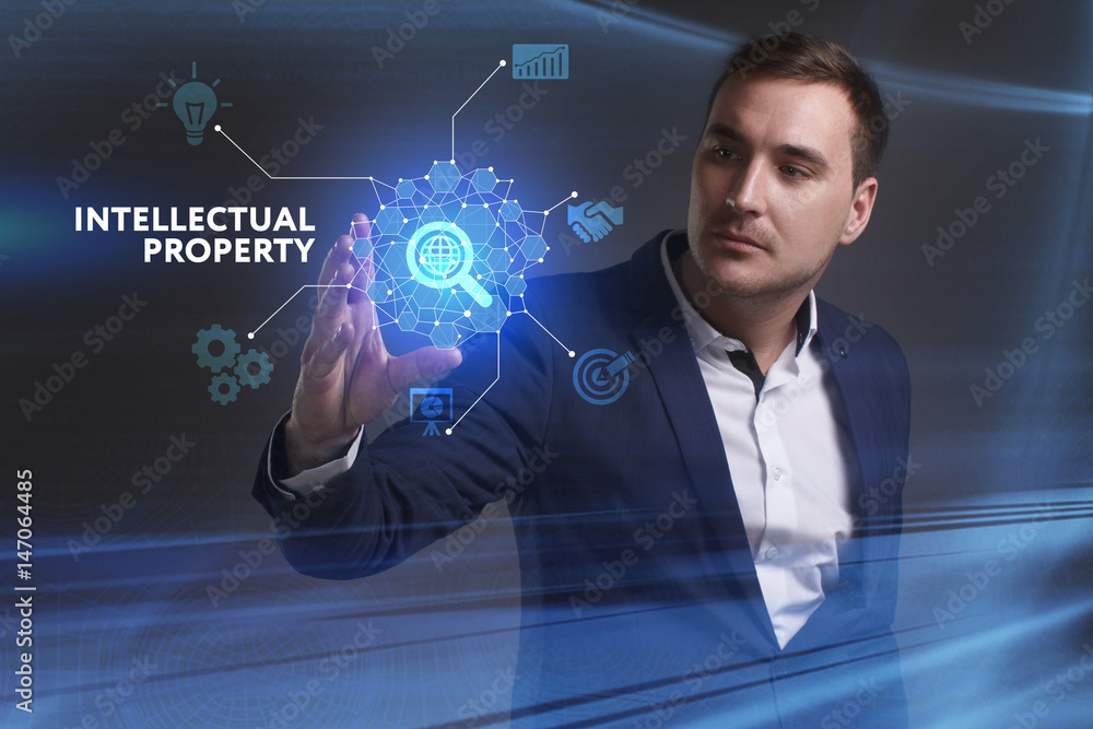 Business, Technology, Internet and network concept. Young businessman working on a virtual screen of the future and sees the inscription: Intellectual property Business, Technology, Internet and network concept. Young businessman working on a virtual screen of the future and sees the inscription: Intellectual property