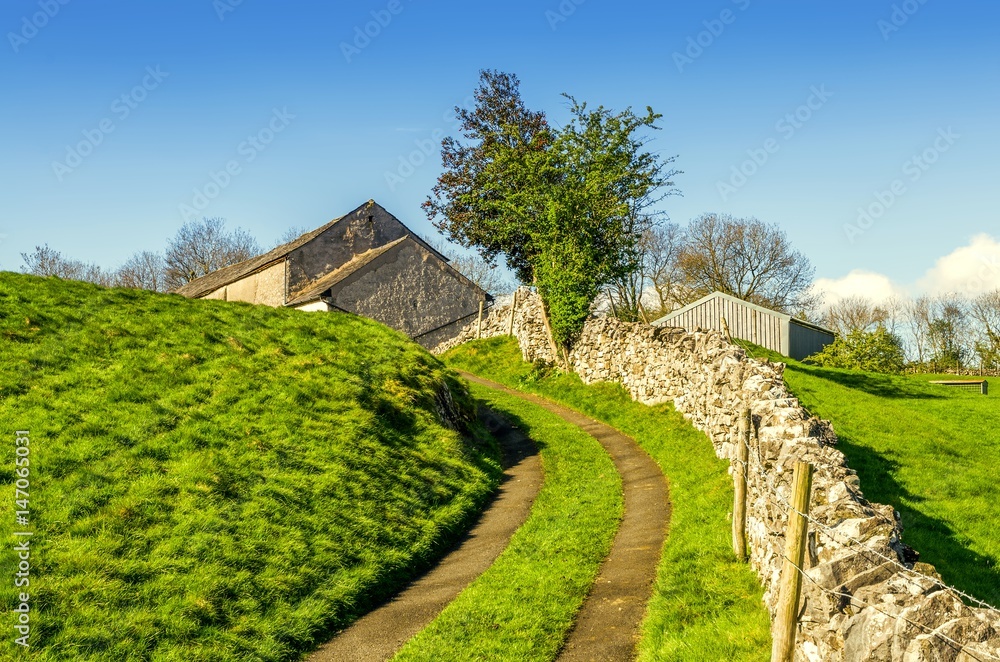 Winding lane leading uphill to a barn