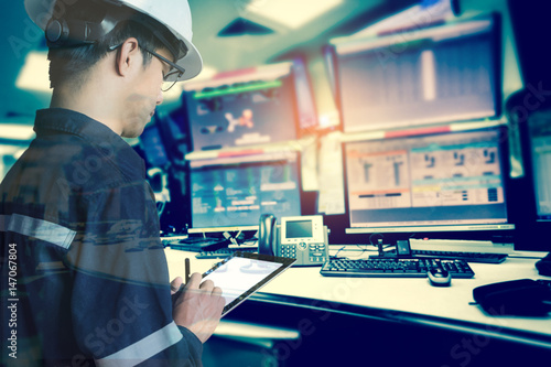 Double exposure of  Engineer or Technician man in working shirt  working with tablet in control room of oil and gas platform or plant industrial for monitor process, business and industry concept