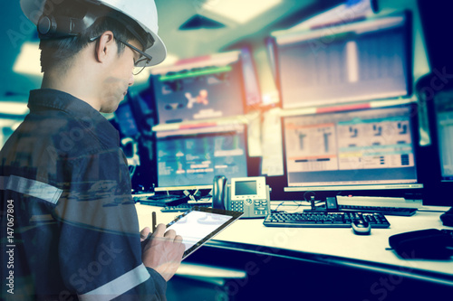 Double exposure of  Engineer or Technician man in working shirt  working with tablet in control room of oil and gas platform or plant industrial for monitor process, business and industry concept photo