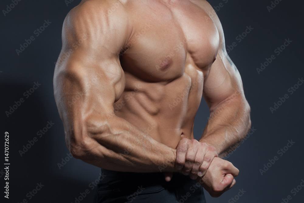 Portrait of strong healthy handsome Athletic Man Fitness Model posing near dark gray wall Portrait of strong healthy handsome Athletic Man Fitness Model posing near dark gray wall