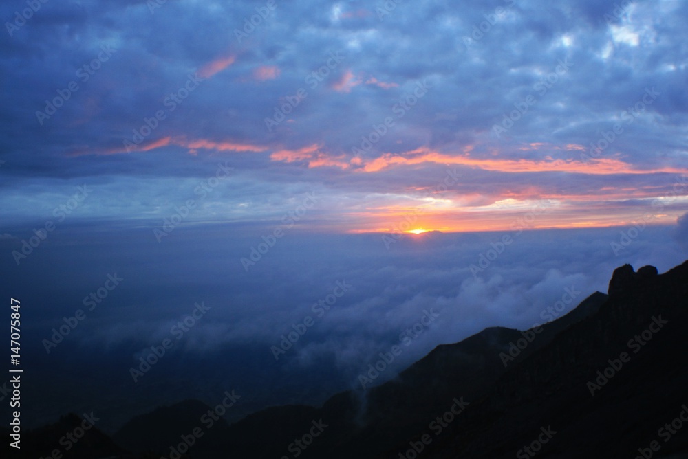 Naklejka premium sun rises over the sky. view in the top of mount merapi