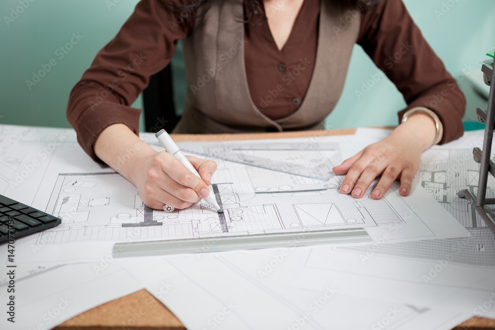 Architect woman at her table drawing on blueprints. Business and creativity. Architecture job Architect woman at her table drawing on blueprints. Business and creativity. Architecture job