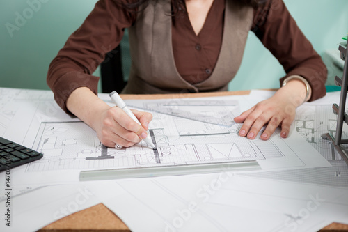 Architect woman at her table drawing on blueprints. Business and creativity. Architecture job