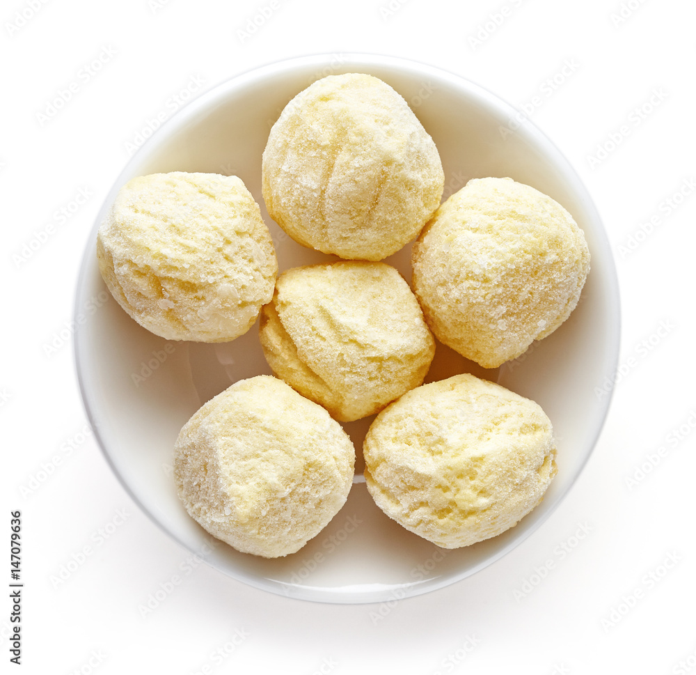 Bowl of frozen potato balls isolated on white, from above