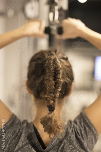 Young woman taking exercises in the gym