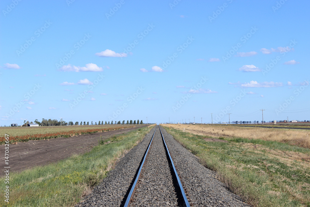 Railway line with crops and highway