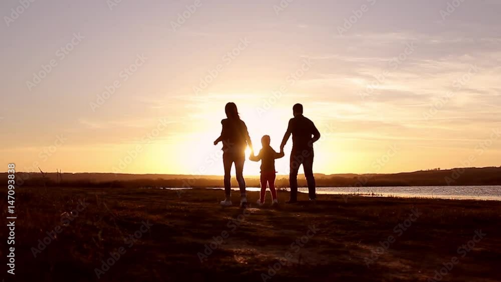 Silhouette, happy child with mother and father, family at sunset, summertime. Run, raising baby up in the air, hugs, love, playing. We are happy family. Silhouette, happy child with mother and father, family at sunset, summertime. Run, raising baby up in the air, hugs, love, playing. We are happy family.