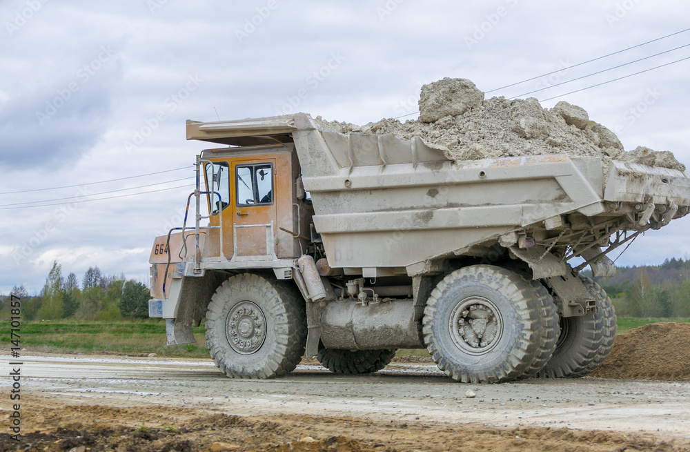 Large-yellow quarry dump trucks produce transportation of minerals Large-yellow quarry dump trucks produce transportation of minerals