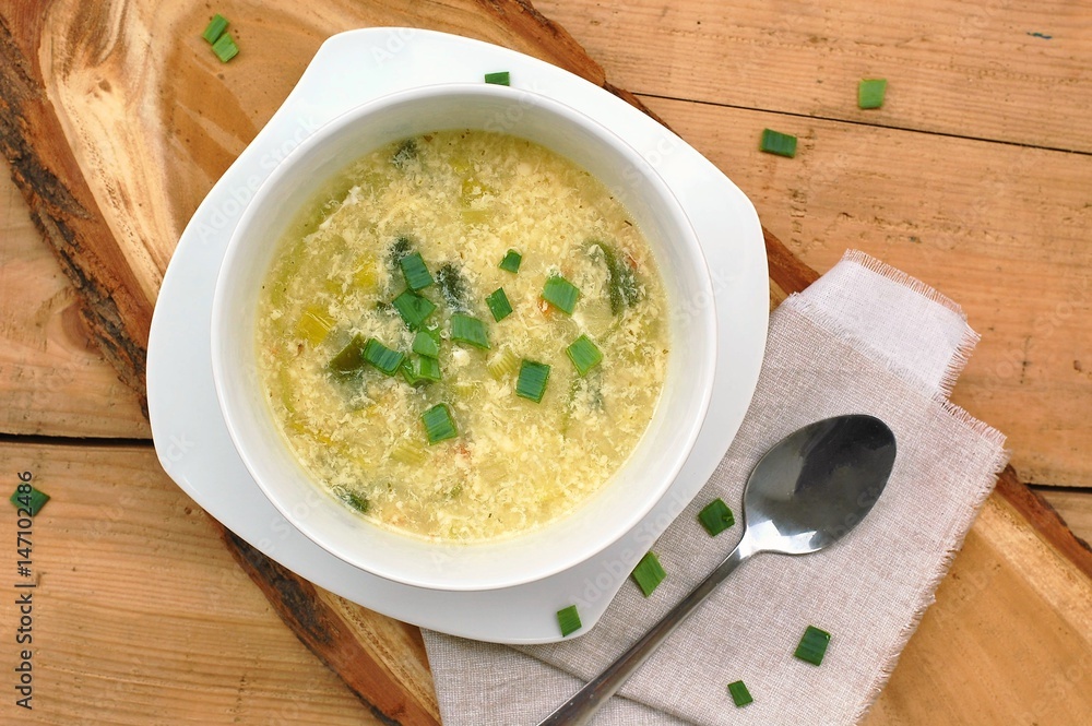 gluten free soup from leek, egg, polenta and parmesan on wooden background gluten free soup from leek, egg, polenta and parmesan on wooden background