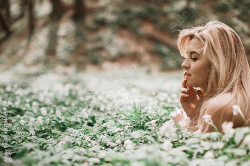 Foto Thoughtful lady with blonde hair lies on the lawn