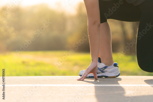 girl runner at the start on asphalt treadmill