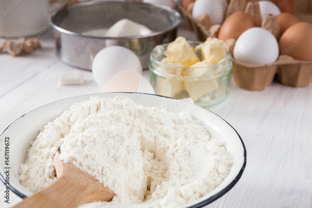 Baking ingredients on white rustic wood background, closeup