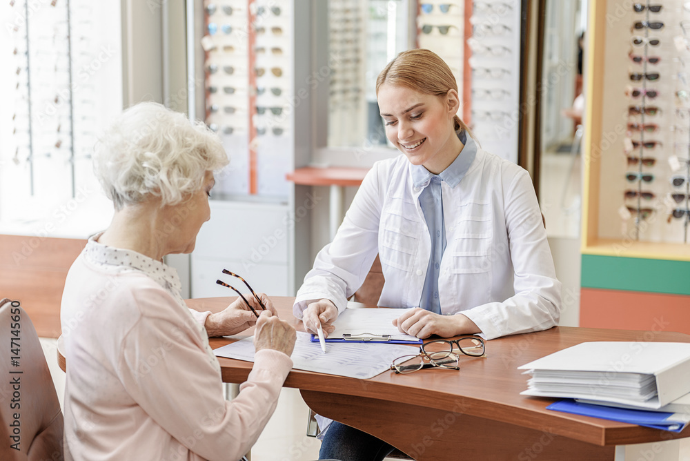 Fototapeta premium Attentive smiling young store assistant working