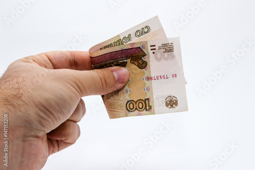 A close up photo of a Caucasian male hand holding a 100 russian ruble note