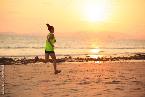 Healthy lifestyle young fitness woman running at morning beach