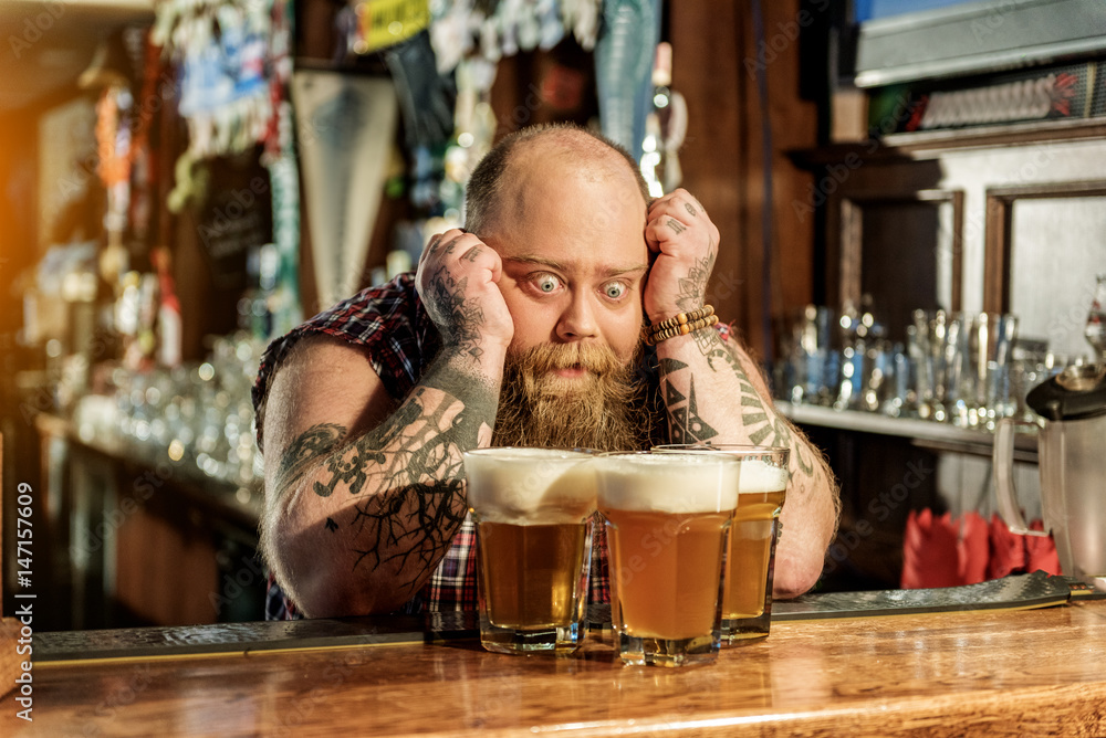 Wonder bearded male watching at beer