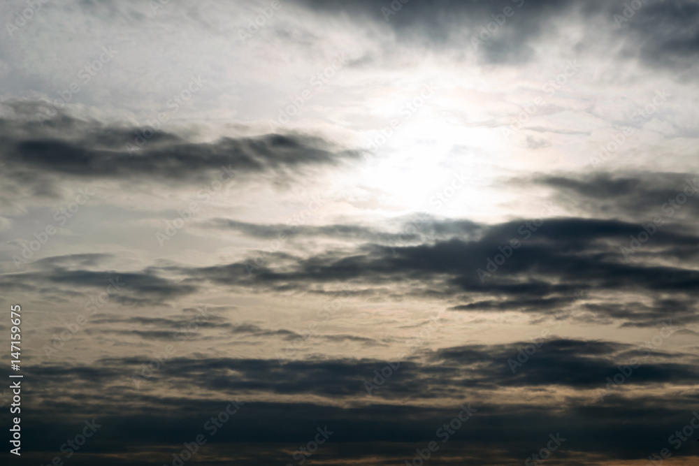 The dark sky, the evening sun, the clouds in a line along the horizon.