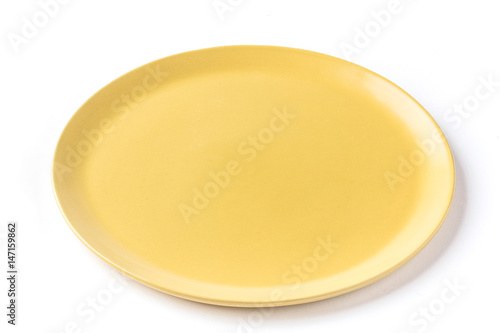 Close up of a round yellow plate on a  white background